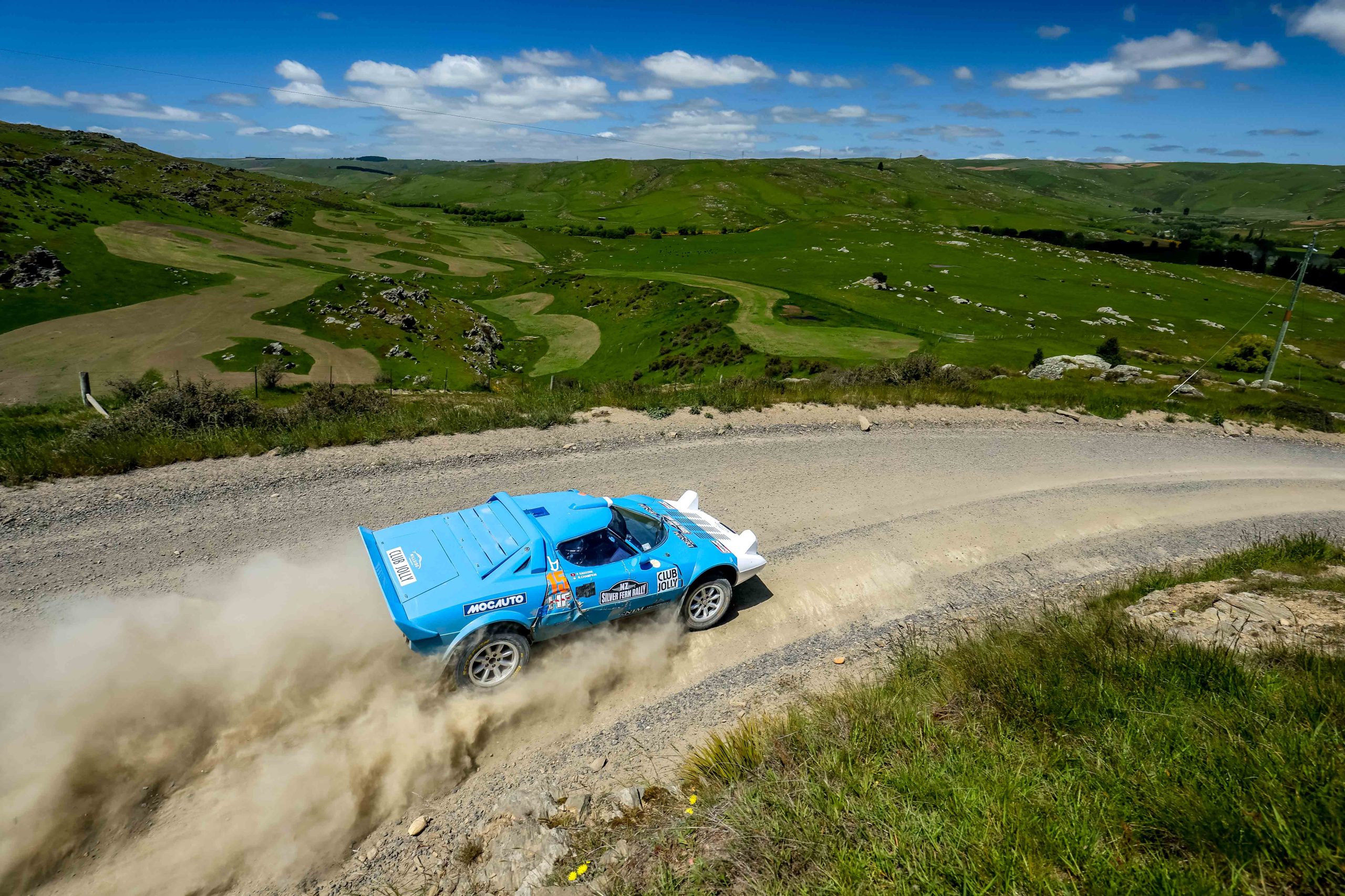 Classic 4WD rally car carving through gravel